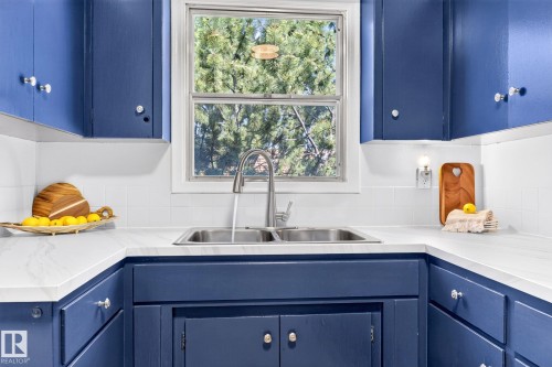 Corner kitchen sink featuring a stainless steel double basin and a gooseneck faucet - 16152 110B Avenue Nw, Edmonton, AB - Indoor Photo Showing Kitchen With Double Sink