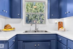Corner kitchen sink featuring a stainless steel double basin and a gooseneck faucet - 