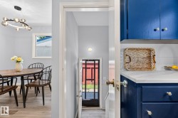 Kitchen featuring blue cabinetry, white countertop, and white subway tile backsplash - 