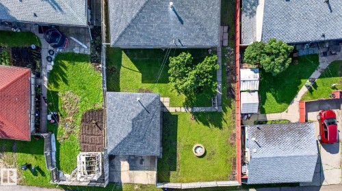 Expansive property featuring a detached garage, a significant green lawn area, a mature tree, paved pathways, and a fire pit - 16152 110B Avenue Nw, Edmonton, AB - Outdoor