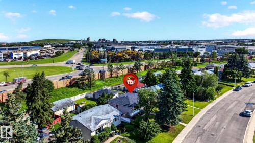 Single-family residence with a dark shingle roof and light-colored siding, surrounded by mature trees - 16152 110B Avenue Nw, Edmonton, AB - Outdoor With View