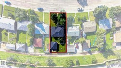 Aerial perspective showcasing a rectangular property with a main residence and a smaller detached structure - 