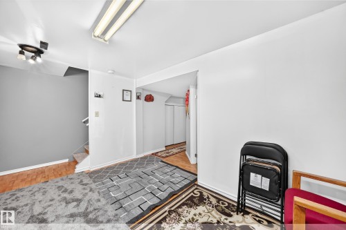 Interior space featuring a white painted wall, a neutral-toned carpeted floor, and a wood-finish flooring section - 243 Abbotsfield Road Nw, Edmonton, AB - Indoor