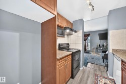 Compact kitchen featuring wood-finish cabinetry, granite-style countertops, an electric range, and a built-in microwave - 