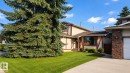 Exterior featuring stucco siding with timber accents, a brown shingle roof, and a mature evergreen tree - 1022 106 Street Nw, Edmonton, AB  - Outdoor 