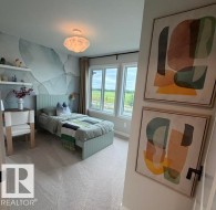 Bedroom featuring broad windows, light-colored carpeting, and a unique ceiling light fixture - 