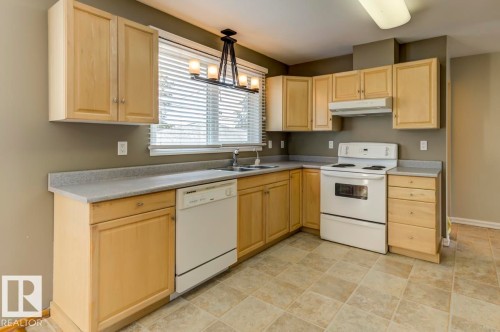 Kitchen featuring light wood-finish cabinetry and light countertops - 8511 64 Avenue, Edmonton, AB - Indoor Photo Showing Kitchen With Double Sink