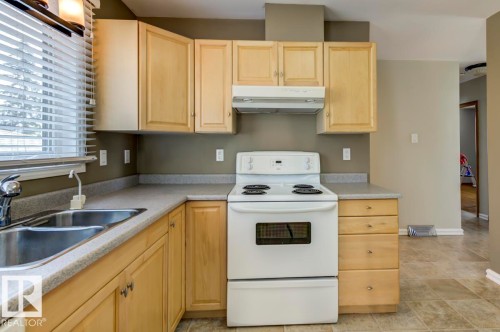 Functional kitchen with light wood-finish cabinetry and a double basin stainless steel sink - 8511 64 Avenue, Edmonton, AB - Indoor Photo Showing Kitchen With Double Sink