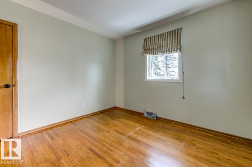 Room with light-toned walls, wood-finish flooring, and a single window - 8511 64 Avenue, Edmonton, AB - Indoor Photo Showing Other Room