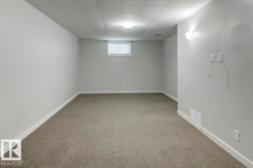 Spacious room featuring neutral carpeting, light gray wall paint, and white trim - 8511 64 Avenue, Edmonton, AB - Indoor Photo Showing Other Room
