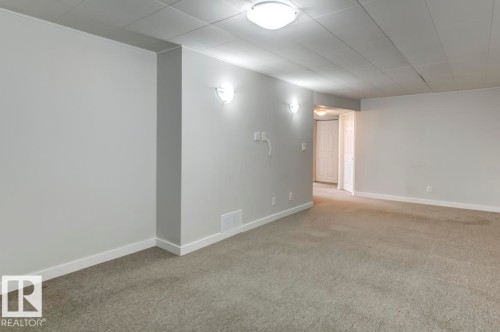 Spacious room featuring neutral carpeting, light gray wall paint, and white trim - 8511 64 Avenue, Edmonton, AB - Indoor Photo Showing Other Room