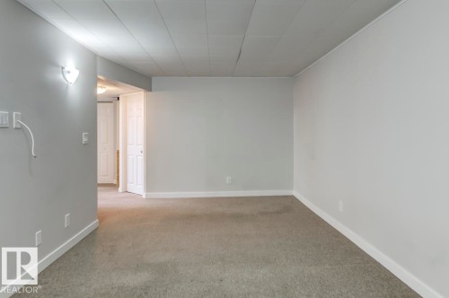 Spacious room featuring light gray walls, white trim, and light gray carpet flooring - 8511 64 Avenue, Edmonton, AB - Indoor Photo Showing Other Room