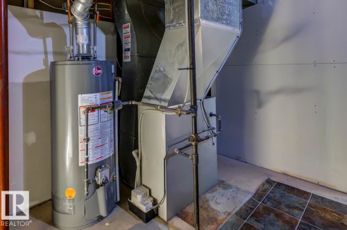 Utility area featuring a water heater, furnace, and exposed ductwork - 8511 64 Avenue, Edmonton, AB - Indoor Photo Showing Basement