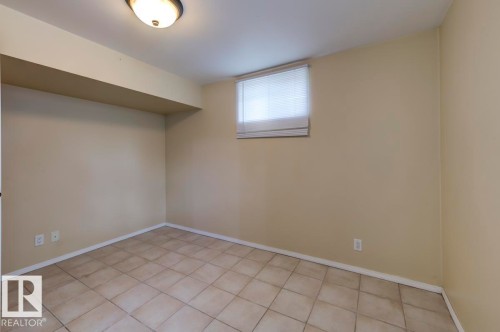 Room featuring ceramic tile flooring, neutral wall paint, white baseboards, and a single window with blinds - 8511 64 Avenue, Edmonton, AB - Indoor Photo Showing Other Room