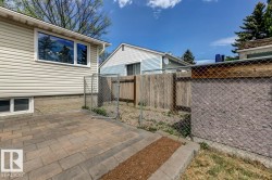 Paved patio area featuring interlocking pavers with a stone border - 