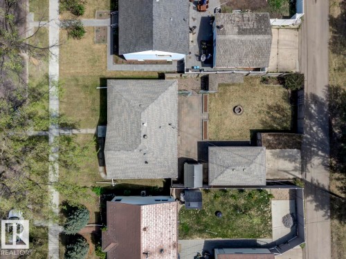 Overhead property view featuring a shingled roof, a detached garage, a fire pit area, and a concrete driveway - 8511 64 Avenue, Edmonton, AB - Outdoor