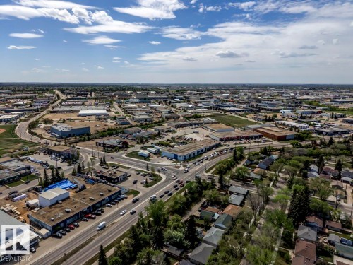 Aerial perspective of a mixed-use district featuring commercial buildings, residential properties, and paved roadways - 8511 64 Avenue, Edmonton, AB - Outdoor With View
