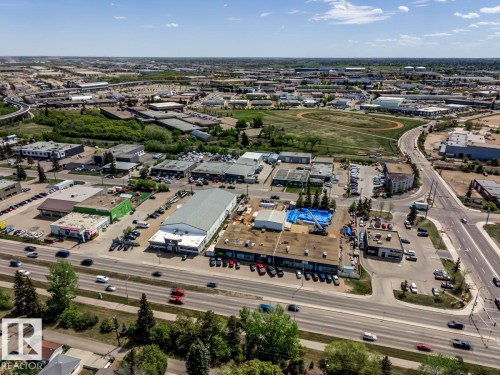 Aerial perspective of a commercial district featuring multiple business properties, extensive surface parking, and direct access to a multi-lane roadway - 8511 64 Avenue, Edmonton, AB - Outdoor With View