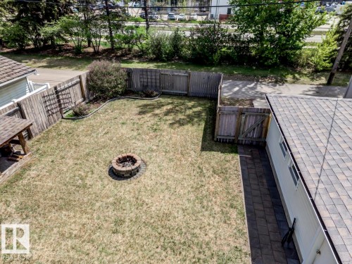 Spacious backyard featuring a stone-ringed fire pit, wood fencing, and a paver patio - 8511 64 Avenue, Edmonton, AB - Outdoor