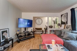 Living area featuring wood-finish flooring, white paneled walls, and a recessed doorway - 