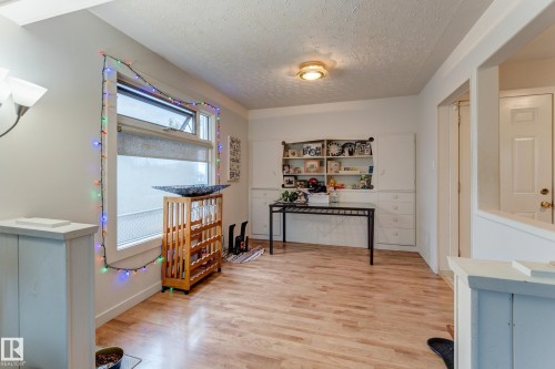 Light wood-finish flooring complements the neutral wall tones - 13211 77 Street Nw, Edmonton, AB - Indoor Photo Showing Other Room