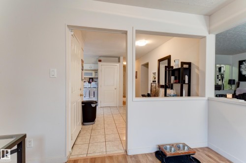 Kitchen area featuring light-toned tile flooring and white cabinetry - 13211 77 Street Nw, Edmonton, AB - Indoor Photo Showing Other Room