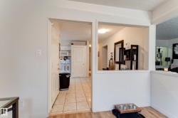 Kitchen area featuring light-toned tile flooring and white cabinetry - 