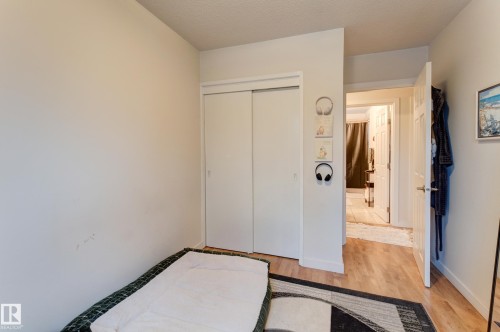 Interior room featuring light-toned walls, wood-finish flooring, and a white sliding closet door - 13211 77 Street Nw, Edmonton, AB - Indoor