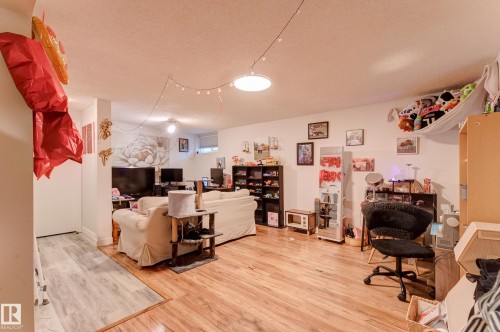 Spacious room featuring wood-finish flooring, white walls, recessed lighting, and a large window - 13211 77 Street Nw, Edmonton, AB - Indoor