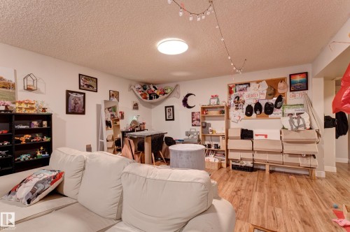 Wood-finish flooring provides a durable surface throughout this expansive room - 13211 77 Street Nw, Edmonton, AB - Indoor Photo Showing Living Room