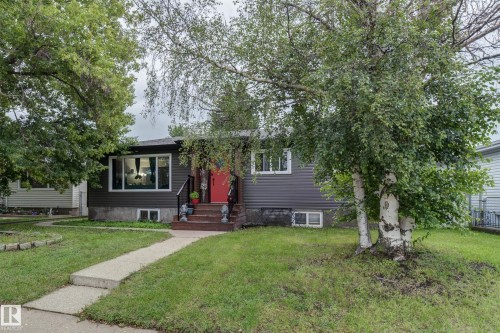 Grey siding exterior with a bright red entry door and white trim windows - 13211 77 Street Nw, Edmonton, AB - Outdoor With Facade