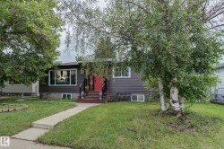Grey siding exterior with a bright red entry door and white trim windows - 
