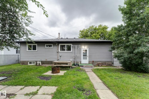 Rear exterior featuring gray horizontal siding, multiple windows, and a white rear entry door - 13211 77 Street Nw, Edmonton, AB - Outdoor
