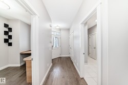 Entryway featuring wood-finish flooring, light gray walls, and white trim - 