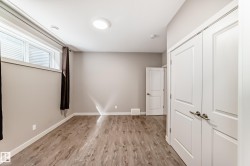 Room featuring wood-finish flooring, neutral wall tones, and white trim - 