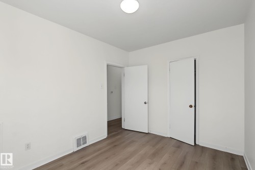 Room featuring wood-finish flooring, white walls, and a flush-mount ceiling light - 11147 78 Avenue Nw, Edmonton, AB 