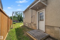 Stucco exterior featuring a white door with divided lites and an overhead awning - 