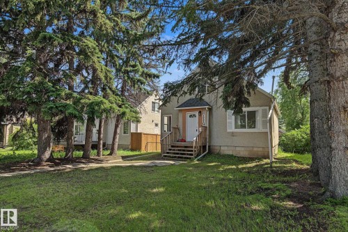 Exterior with textured siding and white trim windows - 11147 78 Avenue Nw, Edmonton, AB 