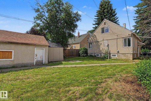 Expansive rear yard featuring a detached garage with a shingle roof and a separate storage shed - 11147 78 Avenue Nw, Edmonton, AB 