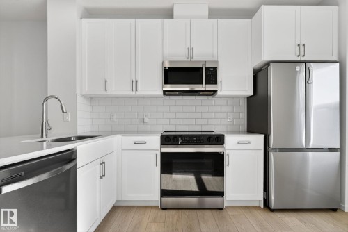 Contemporary kitchen featuring white shaker cabinetry and stainless steel appliances - 264 Orchards Boulevard Sw, Edmonton, AB - Indoor Photo Showing Kitchen