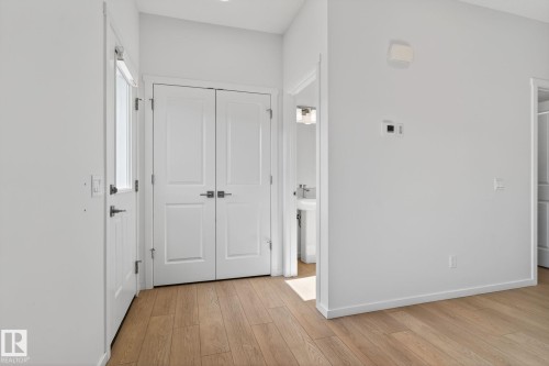 Entryway featuring light wood-finish flooring, white walls, and bright overhead lighting - 264 Orchards Boulevard Sw, Edmonton, AB - Indoor Photo Showing Other Room