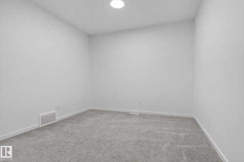 Carpeted room featuring light gray walls, white baseboards, and a recessed ceiling light - 264 Orchards Boulevard Sw, Edmonton, AB - Indoor Photo Showing Other Room
