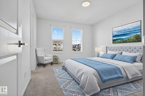 Bright bedroom featuring two large windows, a tufted upholstered bed frame, and plush carpet flooring - 264 Orchards Boulevard Sw, Edmonton, AB - Indoor Photo Showing Bedroom
