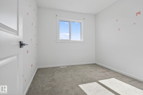 Neutral-toned carpet flooring complements light wall finishes - 264 Orchards Boulevard Sw, Edmonton, AB - Indoor Photo Showing Other Room