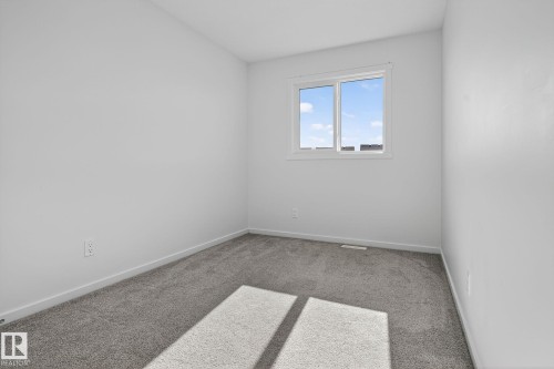 Neutral-toned room featuring a single window and plush gray carpeting - 264 Orchards Boulevard Sw, Edmonton, AB - Indoor Photo Showing Other Room