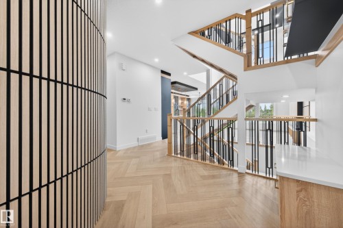 Contemporary staircase featuring wood-finish railings and black metal balusters - 431 172 Avenue, Edmonton, AB - Indoor Photo Showing Other Room