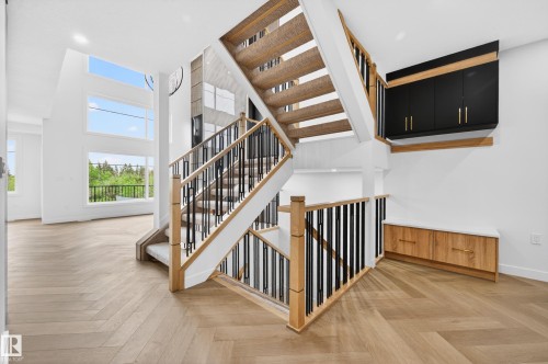 Two-story staircase featuring wood newel posts, black metal balusters, and carpeted treads - 431 172 Avenue, Edmonton, AB - Indoor Photo Showing Other Room