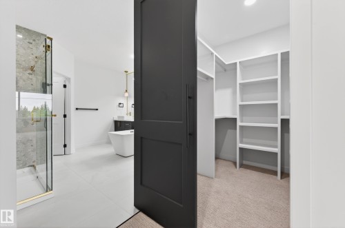 Walk-in closet with built-in shelving, carpet flooring, and a barn door entry - 431 172 Avenue, Edmonton, AB - Indoor Photo Showing Other Room