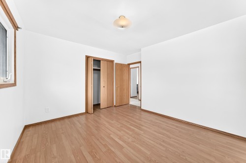 Neutral interior featuring wood-finish flooring, white walls, and wood trim - 10819 137 Avenue Nw, Edmonton, AB - Indoor Photo Showing Other Room