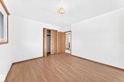 Neutral interior featuring wood-finish flooring, white walls, and wood trim - 